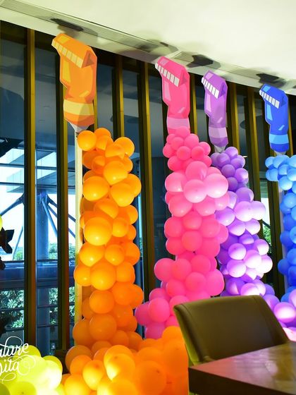 I used columns of colourful balloons to represent giant crayons, a creative and impactful way to decorate the space and stick to the art theme.
