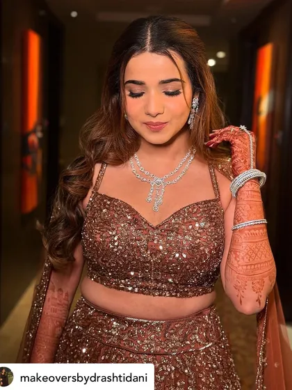 This shot showcases the intricate details of her makeup and henna. The soft smokey eye and nude lip are a perfect combination for this glamorous look.