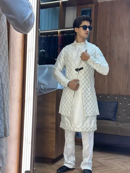 An all-white ensemble is timeless. This look features a silk kurta with a matching embroidered open jacket, creating a sophisticated and elegant outfit for any special occasion.
