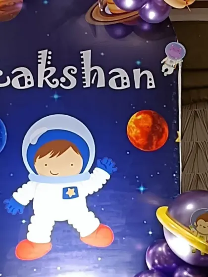 The custom-designed backdrop for Lakshan's space party, featuring a cute astronaut illustration and planets.