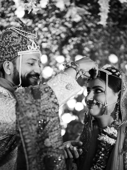 A timeless black and white shot of the Maang Bharai ritual. This conversion emphasizes the emotion and intimacy of the moment when the groom welcomes the bride as his partner for life.