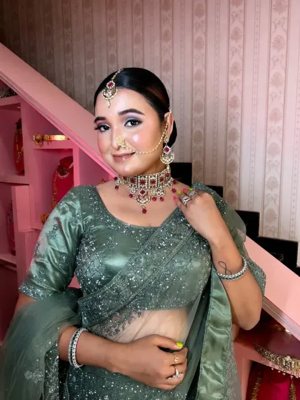 A modern North Indian reception look. The sage green lehenga is paired with a soft smokey eye and a glossy nude lip for a chic and glamorous style.