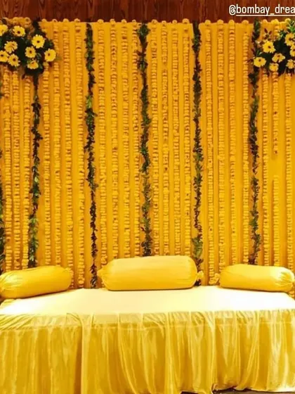 A classic Haldi backdrop made of dense marigold strings, perfect for traditional and elegant home ceremonies.