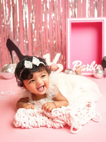 Giggles and glam. This little one is having a blast during her pink and sparkly half-birthday session.