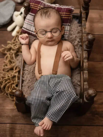 An overhead shot of the chubby baby boy, looking so peaceful and stylish in his vintage-inspired outfit.