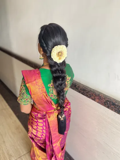 A classic South Indian braid with a simple, elegant floral arrangement at the top.