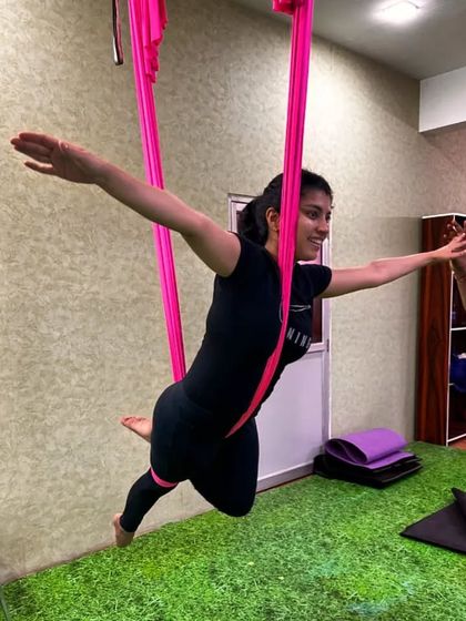 The pure joy of flying. This student's smile says it all as she masters a suspended pose, feeling light and free.
