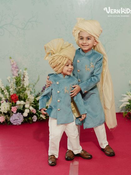 The sweetest brother duo, dressed in matching custom blue sherwanis with elegant turbans. We love creating coordinated outfits that make family photos and wedding memories even more special.