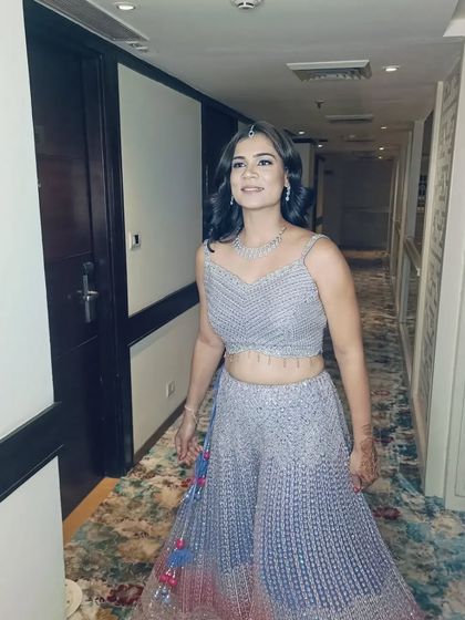 A full-length shot of a client in a stylish sharara set, with her hair in soft waves. The hairstyle complements her modern ethnic outfit perfectly.