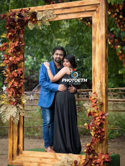 A creative pre-wedding portrait using a large, empty picture frame as a prop. It’s a fun way to frame the couple and add a unique element to their outdoor shoot.