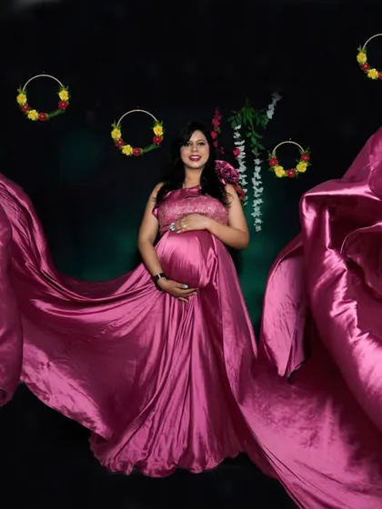A studio session allows for complete control over lighting to create dramatic effects. Here, a flowing pink gown becomes a work of art, showcasing the mom-to-be in a powerful and glamorous solo portrait.