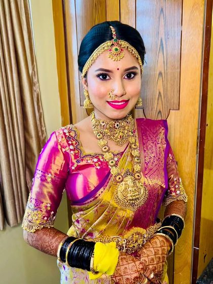 This bride is all set for her wedding. The combination of the bright saree, heavy gold jewellery, and radiant makeup creates a truly unforgettable bridal look.