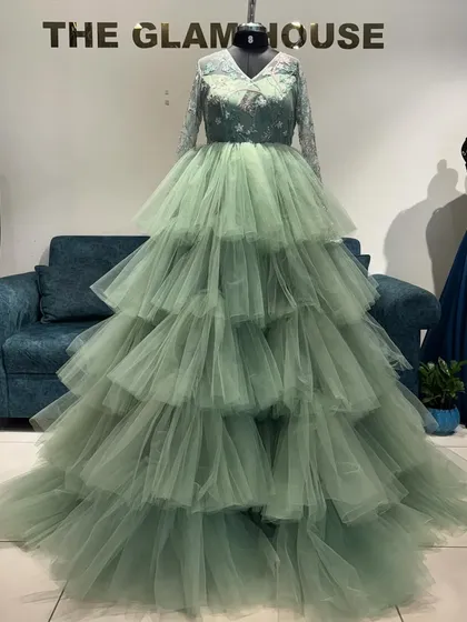 Who says you can't have drama? This pastel green reception gown is all about making an entrance. I designed it with endless layers of tulle and delicate embroidery on the bodice for a look that's both dreamy and a total power move.