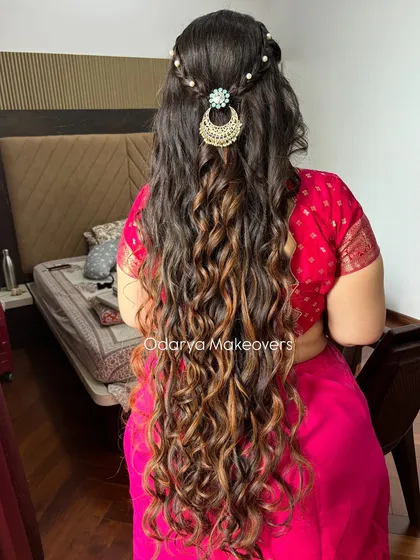 For this naming ceremony look, we created these beautiful, long, flowing curls. The style is enhanced with a simple braid and delicate pearl accessories for a touch of elegance.