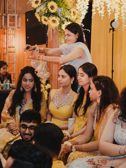 The Kaleerein ceremony is a moment of fun and anticipation. Here, the bride is surrounded by her friends, all eagerly waiting to see who's next.