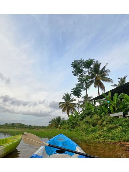A view from the kayak, showing another boat nearby and the green shoreline of our camp.