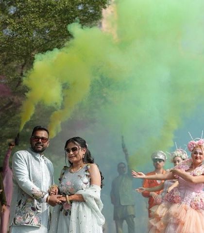 A vibrant and celebratory moment using colorful smoke bombs. This adds a fun and modern twist to a pre-wedding shoot at a heritage location, blending tradition with contemporary style.