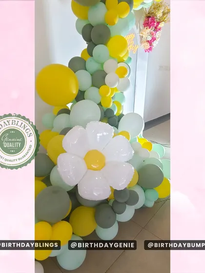 A close-up of a balloon arch with daisy accents, showing the detail of the flower-shaped balloons.