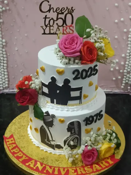 Celebrating 50 years of love. This anniversary cake beautifully depicts the couple's journey from their wedding day in 1975 to their golden anniversary in 2025, decorated with fresh, colorful roses.