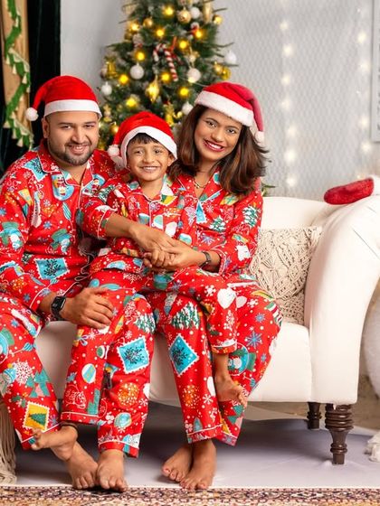 This family is all smiles in their bright red Christmas pyjamas. The candid laughter and cozy couch setting make for a heartwarming holiday photo.