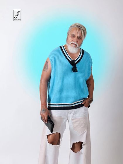 A playful and modern look for a senior model, featuring a bright blue sweater vest and ripped white jeans. The glowing background effect adds a creative touch.