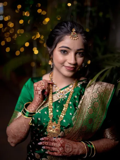 A stunning close-up portrait of the bride, highlighting her intricate gold jewelry and radiant smile.