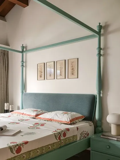 In this bedroom, a mint-green four-poster bed is paired with lilac-painted wardrobes. The contrast of colours, along with the traditional form of the bed and the simple lines of the cabinetry, creates a space that is both whimsical and contemporary.
