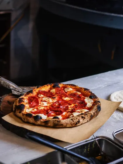 A classic Pepperoni pizza, hot and fresh from the oven, ready to be served. It's a timeless favorite for a reason.