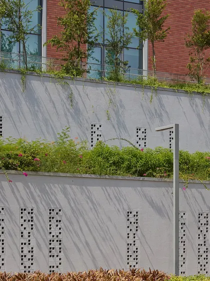 This detail shot shows the integration of landscape and architecture at the Wipro Hyderabad campus. The perforated retaining walls and tiered planters help manage the site's topography while adding green elements that contribute to a cooler microclimate.