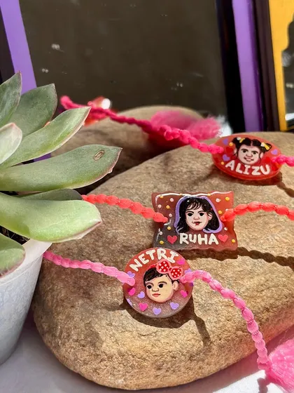 A set of personalized Rakhis for young children, with their cute portraits and names.
