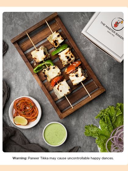 A platter of our Malai Paneer Tikka, showcasing the soft, creamy texture and subtle char marks. It's a milder, richer version of the classic tikka, perfect for those who enjoy less spice.