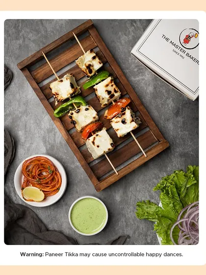 A platter of our Malai Paneer Tikka, showcasing the soft, creamy texture and subtle char marks. It's a milder, richer version of the classic tikka, perfect for those who enjoy less spice.