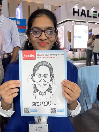 This guest was delighted with her caricature at a dental conference for Toothsi at the Jio World Centre. The paper includes the brand's logo and a QR code for marketing.