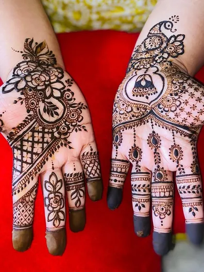 A mix of styles for a unique look, combining a floral Arabic trail on one hand with a peacock and jhumka design on the other.