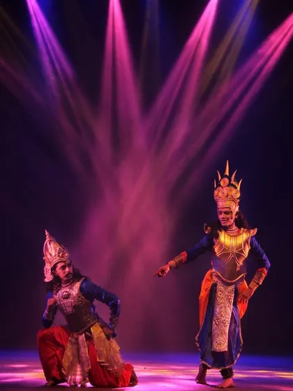 A scene from '18 Days' depicting the complex relationship between Krishna and Arjuna. The lighting and costuming are integral to setting the mood and highlighting the characters' emotional states.