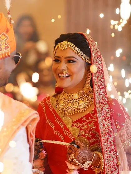 A beautiful moment between the bride and groom. The bride is wearing a stunning all-gold jewellery set from my collection, perfectly complementing her red saree.