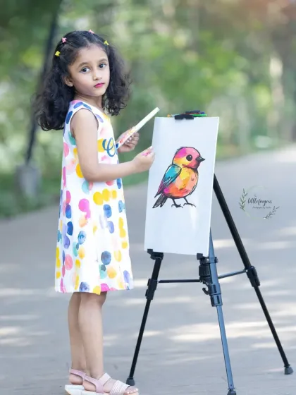 Dressed in a colorful dress that matches her artwork, this young artist is ready for her portrait. The 'Little Artist' theme is one of my most popular creative children's photoshoot ideas.
