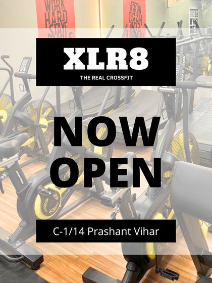 Our "Now Open" sign over a picture of our state-of-the-art air bikes and treadmills at the Prashant Vihar location.