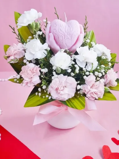 A romantic arrangement of pink and white carnations featuring a heart-shaped candle. A perfect gift to express your love and admiration.