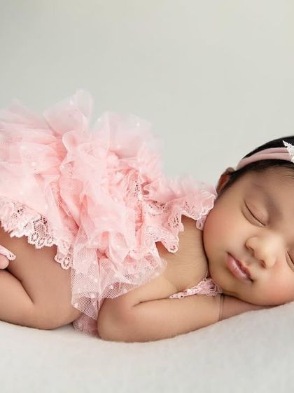 The 'taco' pose in a lovely pink lace romper. The texture of the outfit adds a beautiful detail to this classic newborn pose.