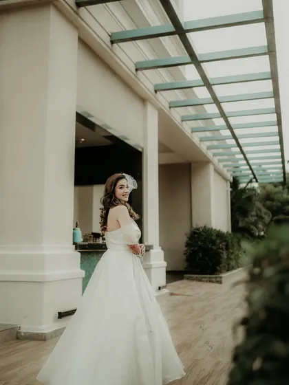 A beautiful, candid shot of the bride in her white gown. Her backward glance and gentle smile create a natural and enchanting portrait, full of grace and movement.
