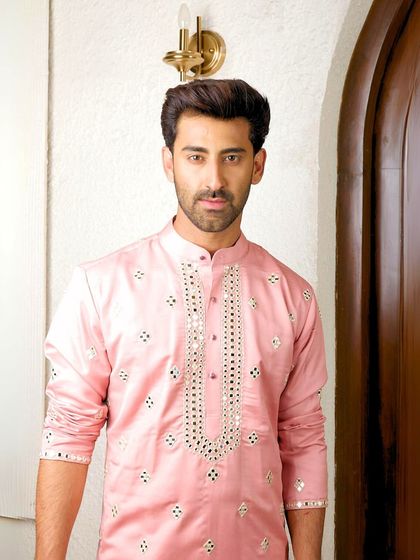 A portrait shot of the pink mirror work kurta, highlighting the detailed embroidery around the neckline and the overall confident style it projects.