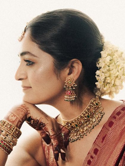 A profile portrait showcasing the bride's serene expression and the beautiful details of her jewelry and hairstyle. The soft, bright light gives this image an ethereal quality.