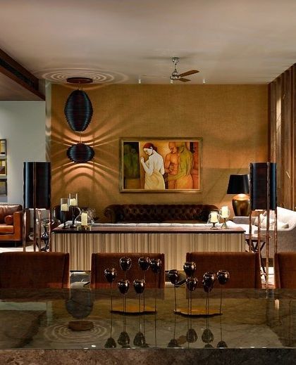 This living and dining space is a perfect example of quiet luxury. Warm lighting, rich textures, and subtle details like the fluted console and tufted leather sofa create an atmosphere of comfort and understated elegance.