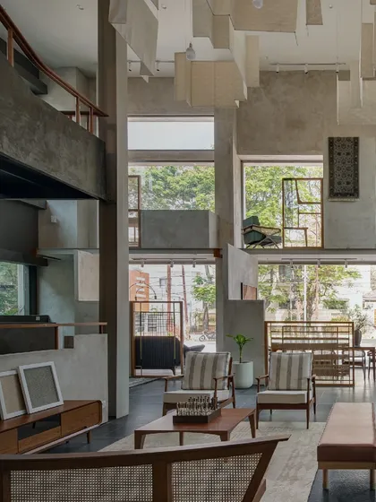 An interior view of the Magari store, showing the double-height space, suspended ceiling panels, and the seamless connection to the outdoors through large windows.