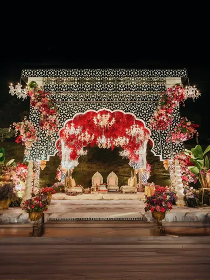 A modern take on Rajasthani royalty. This mandap uses intricate black and white patterns as a backdrop for a dramatic arch of red florals, blending traditional motifs with a bold, contemporary design sensibility.