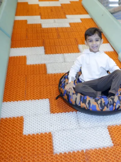A happy boy gives a thumbs-up after a fun ride down the Donut Slide.