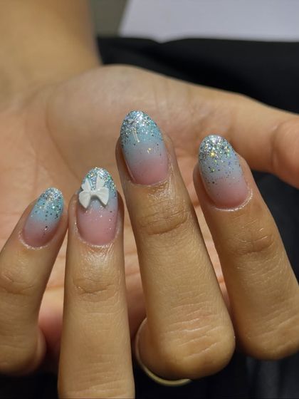 A dreamy, Frozen-inspired look with a blue and pink glitter ombré, accented with a cute 3D white bow.