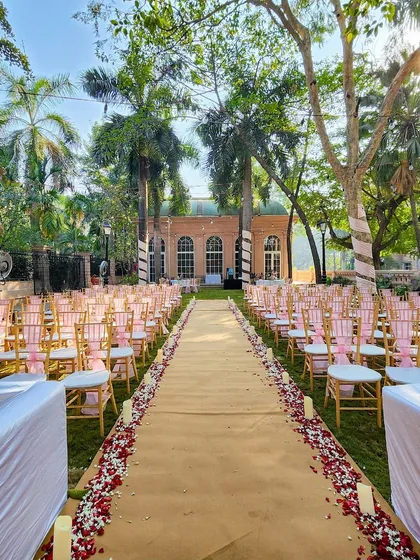 The aisle for this garden wedding is lined with rose petals and candles, leading to a beautiful mandap and creating a truly romantic path for the couple.
