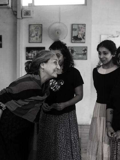 A warm moment of interaction between cast members during a rehearsal.